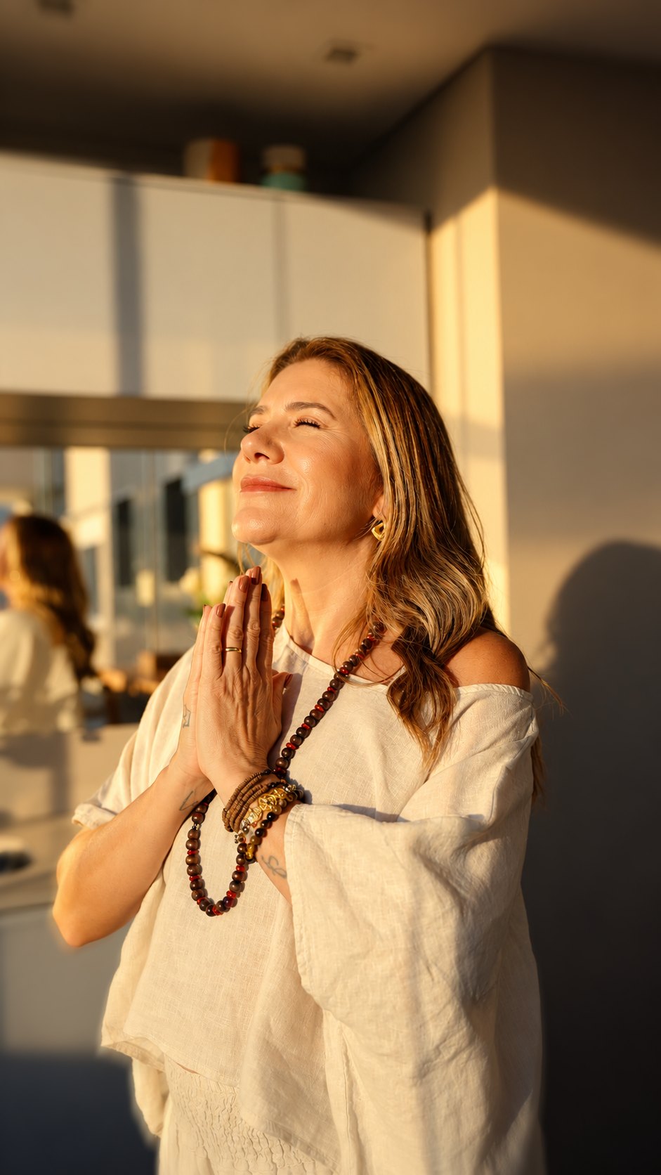 Vanessa de mãos juntas e olhos fechados, na luz do sol