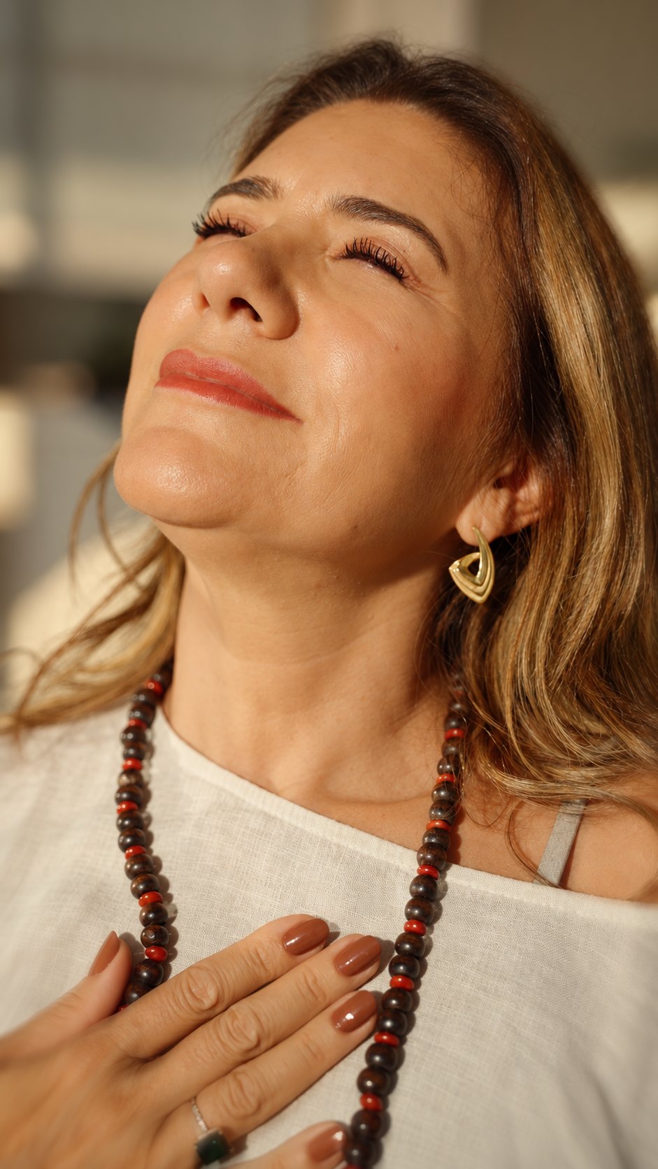 Vanessa com o rosto voltado para cima, de olhos fechados, sorrindo