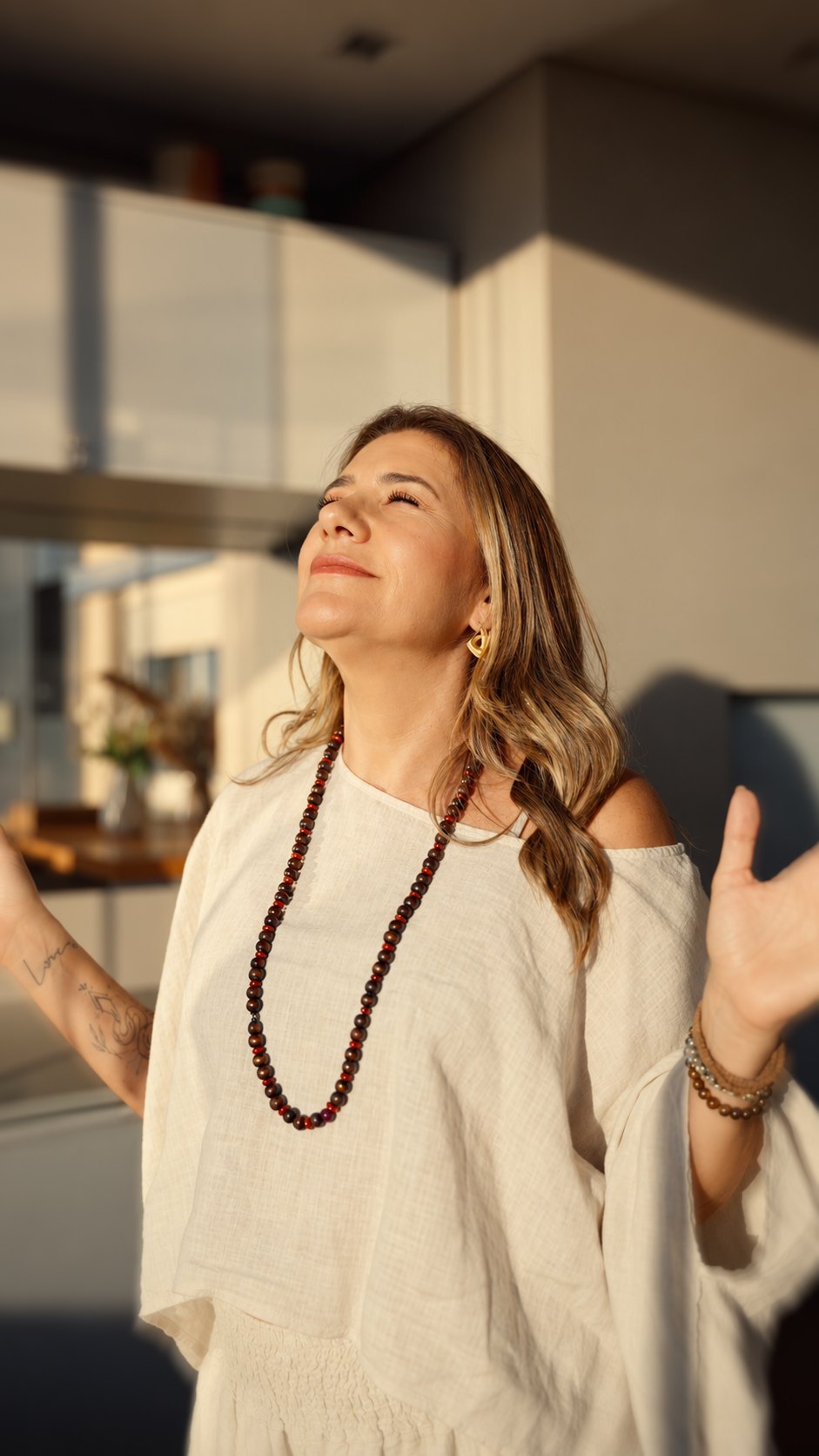 Vanessa de braços abertos, com o rosto no sol